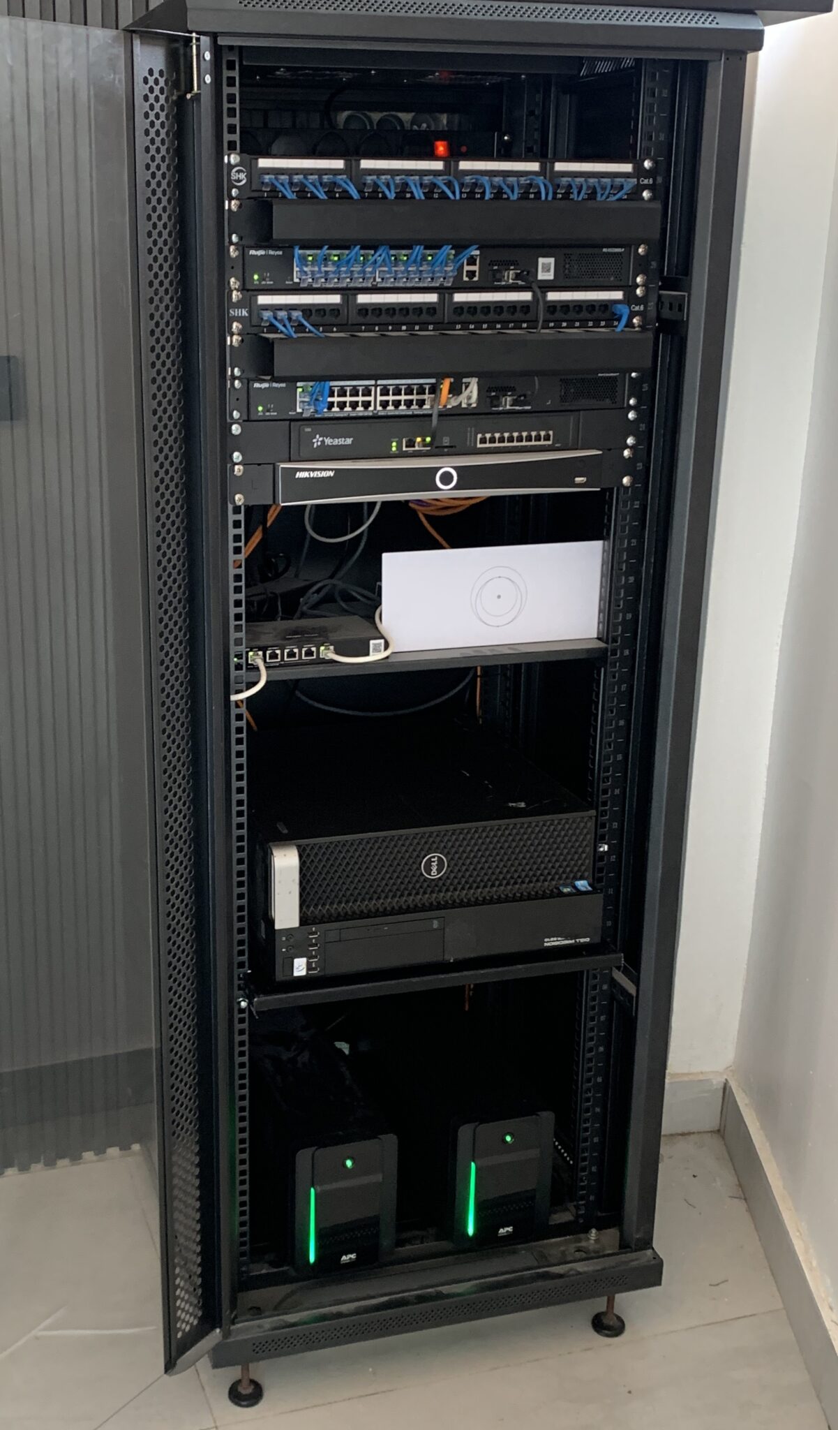 A completed Trahezy rack installation — labeled patch panels, switches, a Yeastar PBX, and an NVR, fully cabled